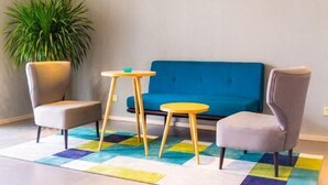 A room with a blue sofa, two armchairs, a small round table, and a colorful rug. - Home Inn Business Hotel (Benxi Railway Station Branch) (Benxi)