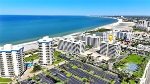 Un hôtel de grande hauteur, avec de nombreux étages, un parking et une vue sur la plage.