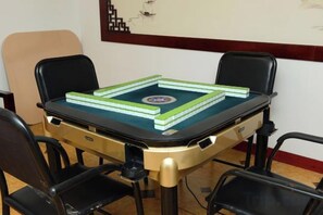 A table with a green and white checkered tablecloth, surrounded by four black chairs. - Wangfu Hot Spring Hotel (Jinghong)