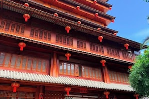 A multi-tiered traditional building with balconies and red lanterns. - Wangfu Hot Spring Hotel (Jinghong)