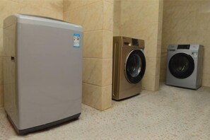 Een wasruimte met een wasmachine en een droger.
