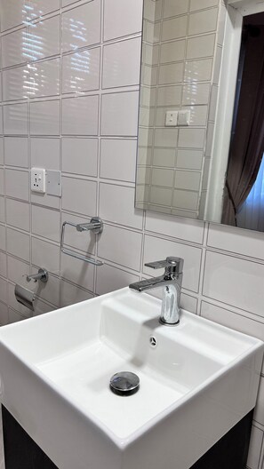 Een douche, handdoeken, zeep, toiletpapier