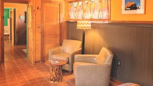 A cozy room with two leather chairs, a small round table, and a lamp.