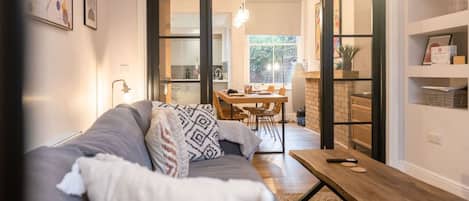 Una sala de estar moderna con un sofá, una mesa de centro y un comedor con sillas y una mesa.
