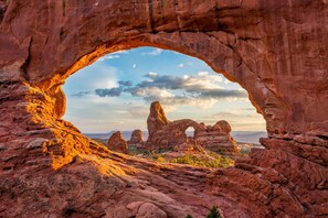 A natural rock arch formation with a clear sky and distant mountains. - Entrada at Moab 619 and 623 (Moab)