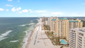 A coastal hotel with a beach view, multiple balconies, and a swimming pool. - Beach Colony West 1C (Pensacola)