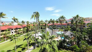 Un resort con varias edificaciones, palmeras y una piscina.