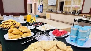 A buffet table with various food items and drinks. - Fortune Hotel (Luxi)