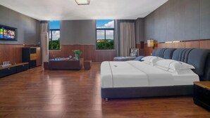 A modern hotel room with a large bed, a flat-screen TV, a desk, and a view of the outdoors. - Fortune Hotel (Luxi)