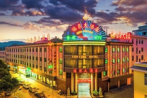 Un hotel de varios pisos con un cartel llamativo, ventanas amplias y una fachada bien iluminada.