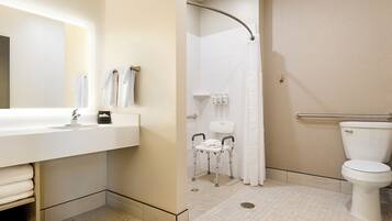 A bathroom with a white sink, a toilet, and a shower area.
