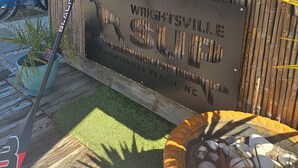 Puinen kyltti, jossa lukee ”Wrightsville Beach, NC”, ja bambusta tehty aita.