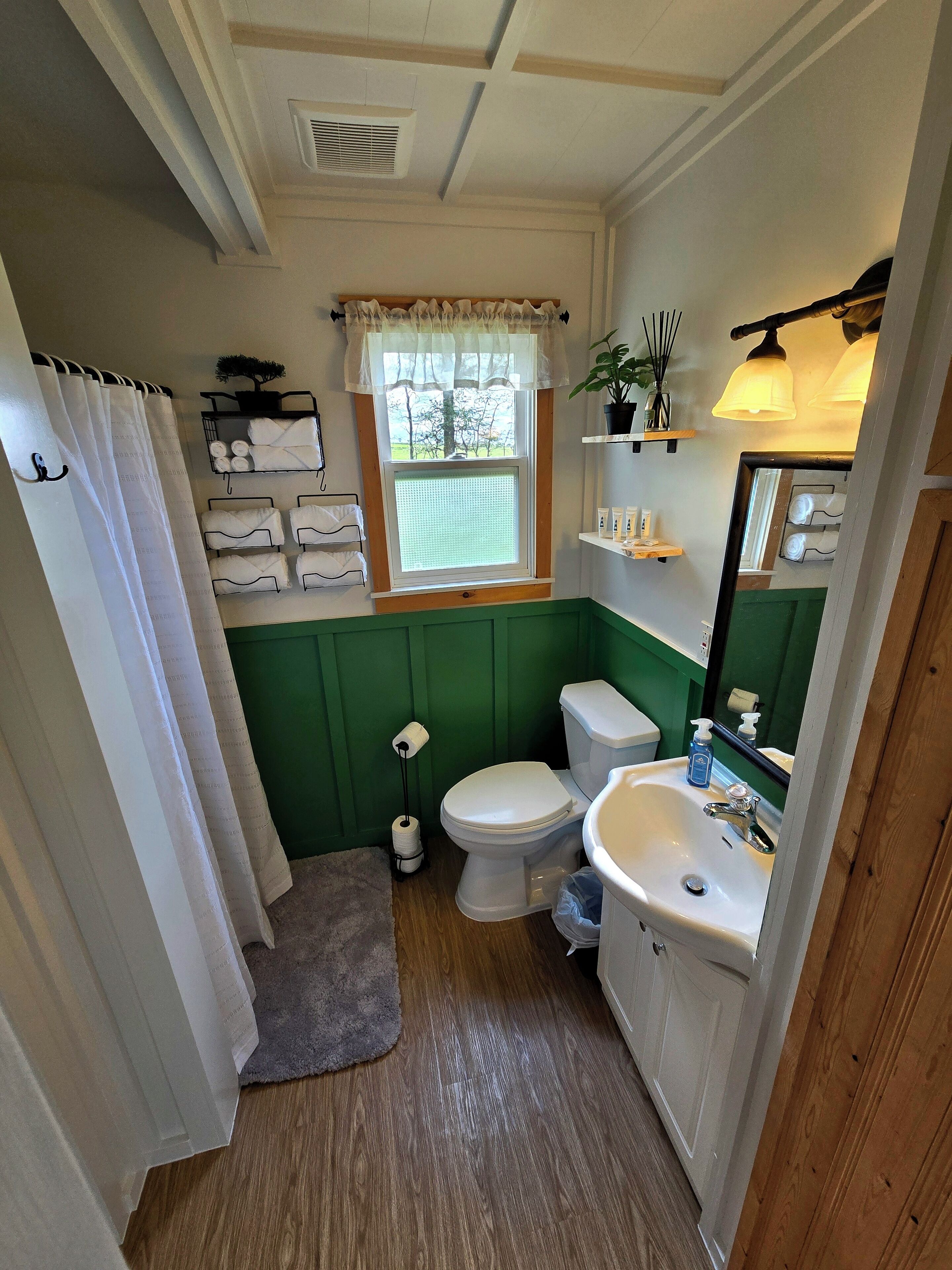 Un baño con inodoro, lavamanos y cortina de ducha.