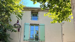 Un edificio con un cartello che riporta "RUE DU PAVE", una porta verde e una finestra con persiane.