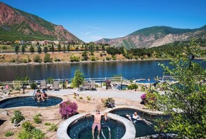 A resort with multiple hot tubs and a lake view.
