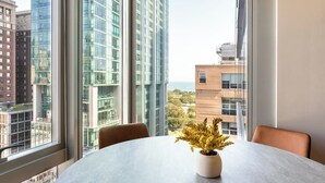 Een moderne kamer met een groot raam, een ronde tafel en een plant in pot.