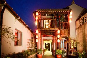 A traditional building with a wooden balcony and lanterns, surrounded by potted plants. - Zhouzhuang Hanshe Ziteng Bieyuan (Kunshan)