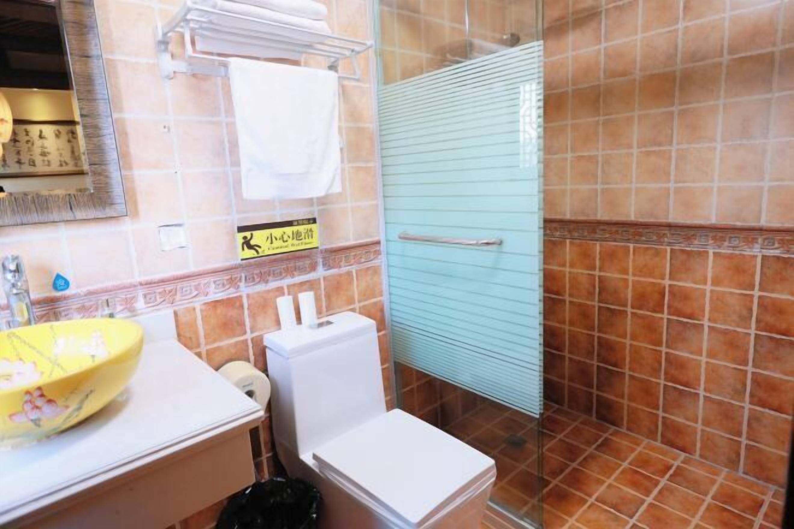 A bathroom with a toilet, sink, and shower area.