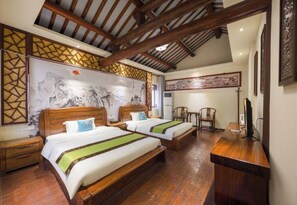 Une chambre d’hôtel avec deux lits en bois, un bureau et un mur décoratif de style traditionnel.