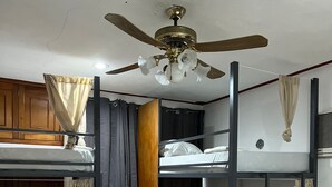 A dormitory room with bunk beds, a ceiling fan, and curtains. - TREEBU HOSTEL (Valladolid)