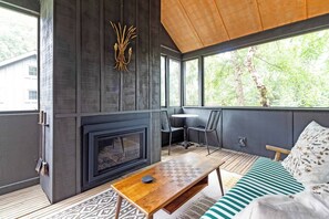 A modern interior with a fireplace, a dining area, and a sofa. - Modern Douglas Hideaway | Hot Tub & Patio (Douglas)