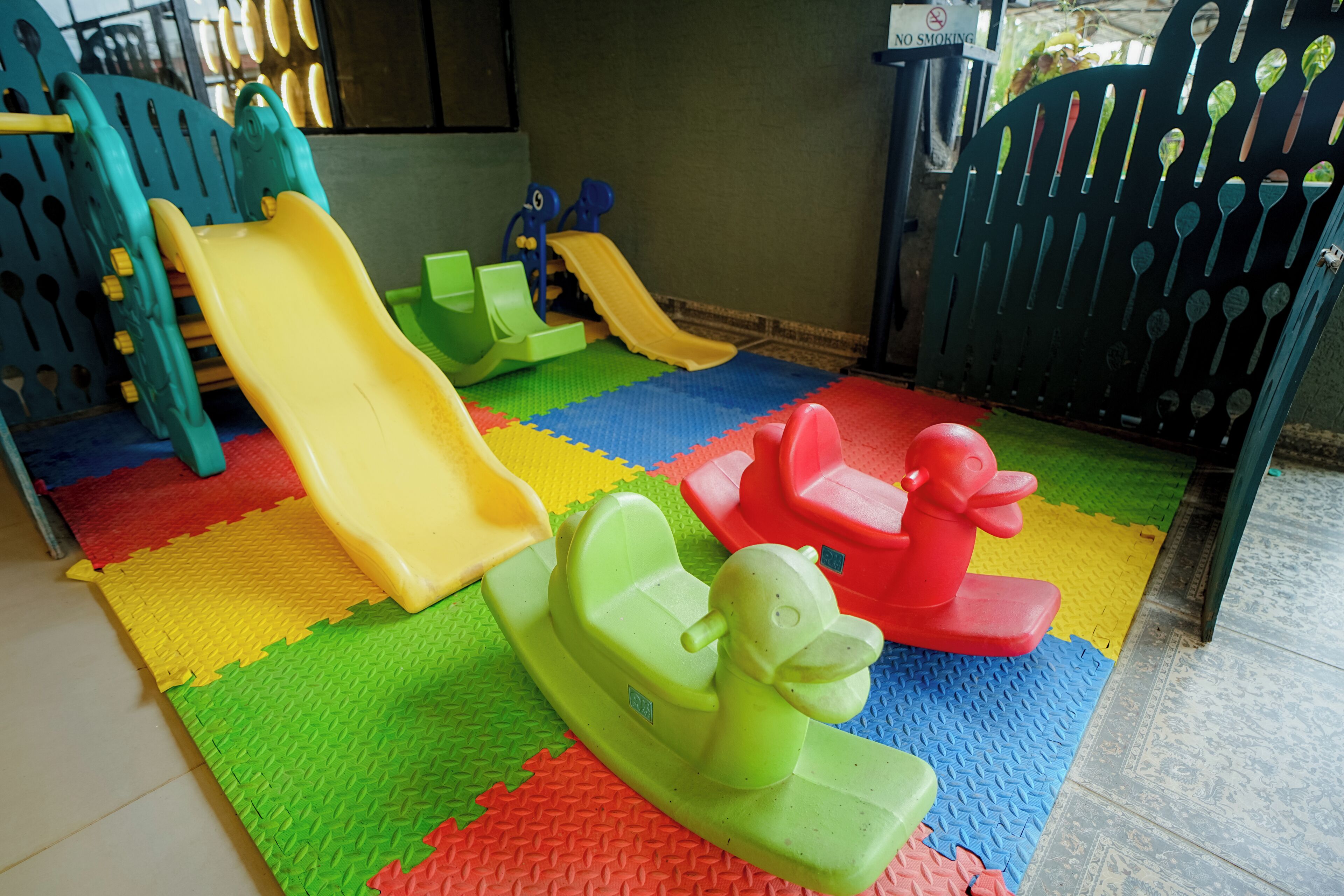 A children's play area with slides and a small green toy boat.