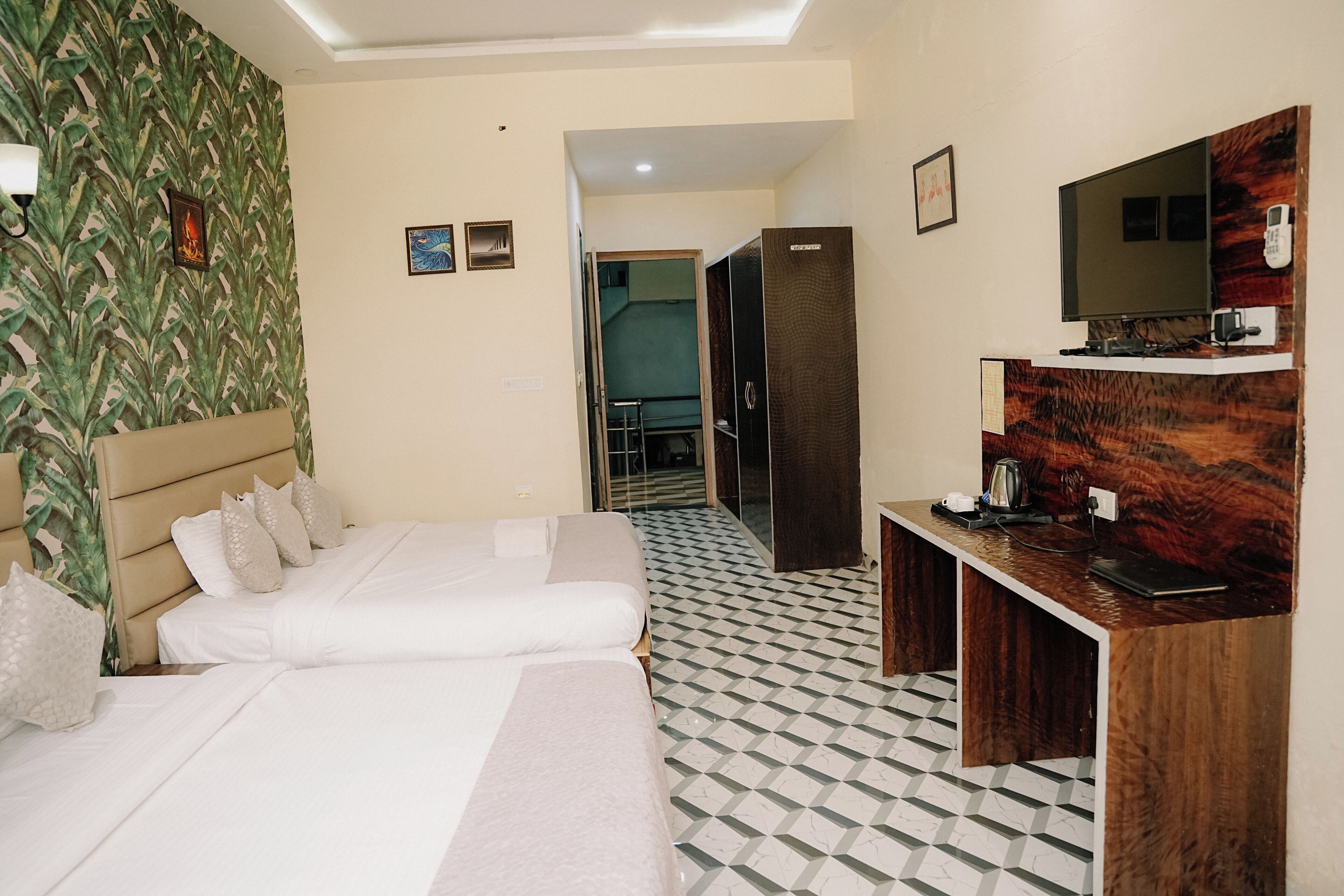 A hotel room with a bed, a desk, a mirror, and a tiled floor.