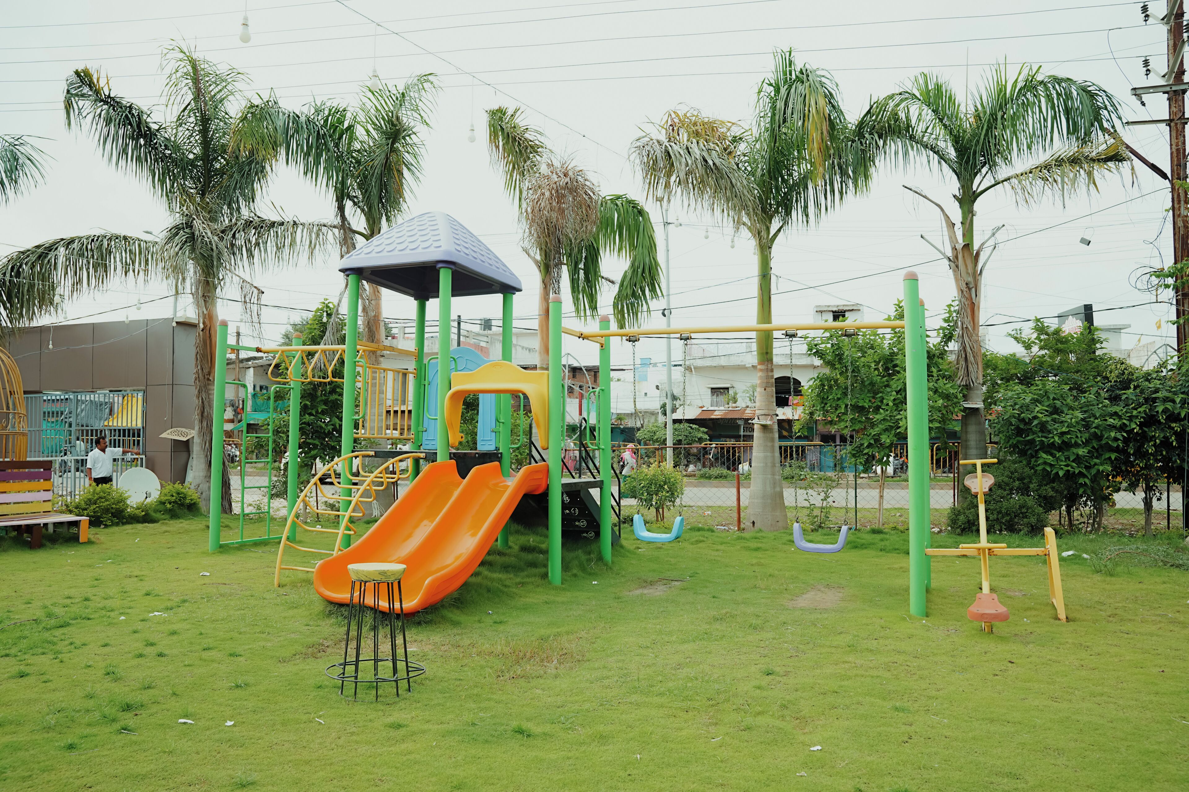 Un parque infantil con tobogán, estructuras para escalar y columpios.