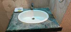 A bathroom sink with a marble countertop and a soap dish. - THE GRAND  (Jabalpur)
