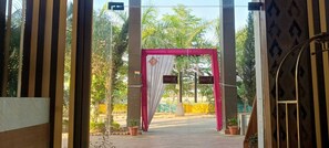 An entrance with a pink archway and 'PULL' signs, leading to a paved area with potted plants. - THE GRAND  (Jabalpur)