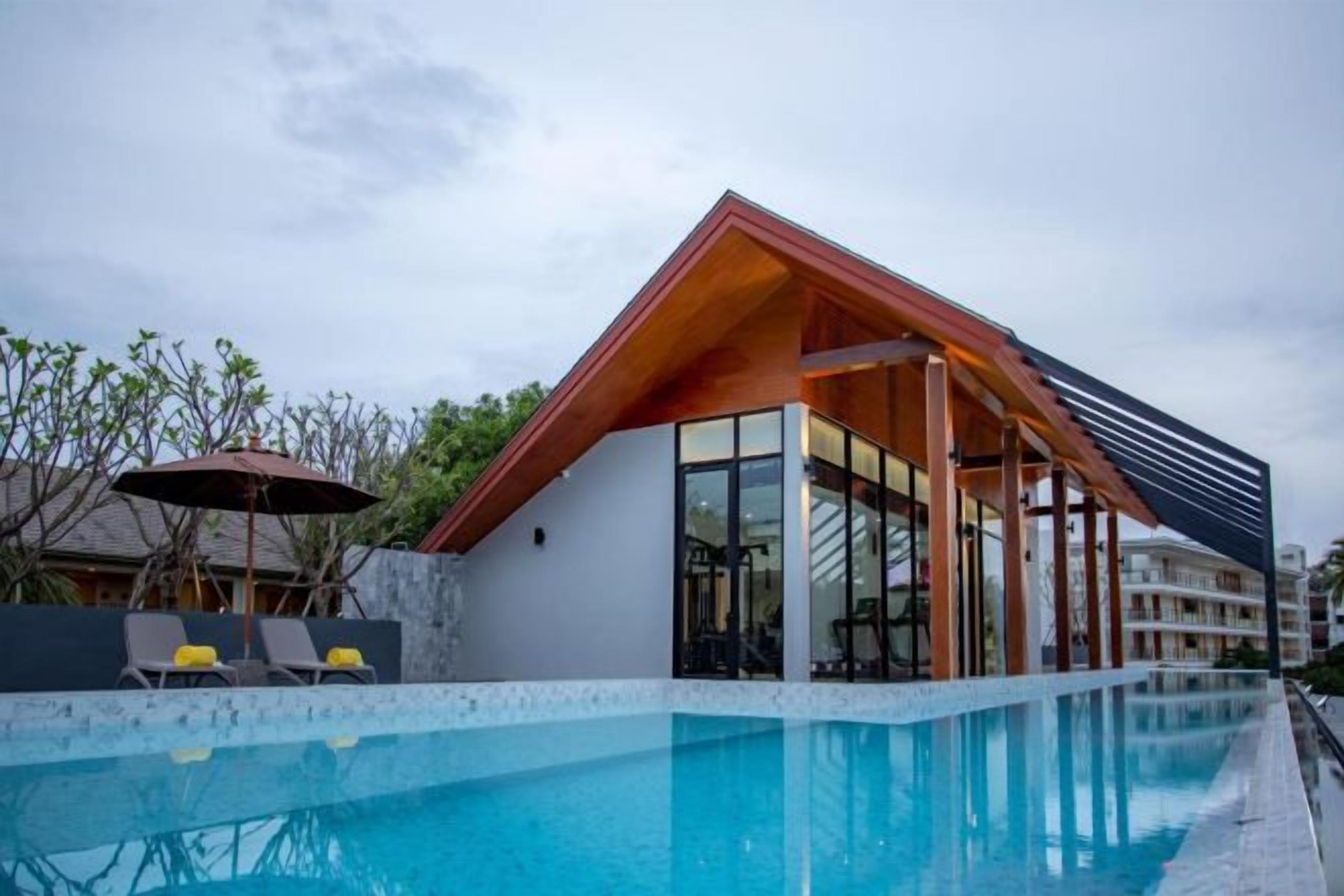 A modern building with a pool, featuring a glass facade and a wooden roof.