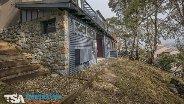 A modern house with a stone facade, a wooden staircase, and a metal exterior. - Golden Eagle 1 - Central Village (Central Village)