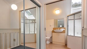 Une salle de bain moderne avec une douche à parois de verre, un lavabo blanc et un grand miroir.