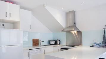 Oven, coffee/tea maker, cookware/dishes/utensils, dining tables