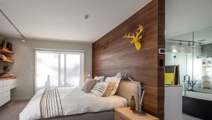 A modern bedroom with a bed, bedside table, and a mounted TV.