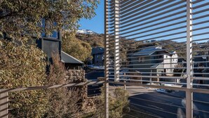 A modern building with a metal facade and a view of houses and trees in the background.