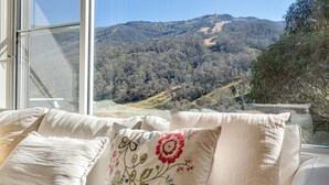 Ein Zimmer mit großem Fenster und Blick auf eine hügelige Landschaft.