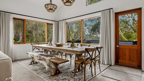 A dining area with a wooden table, chairs, and a fur-covered bench. - Ski In Ski Out #01 (Ski-In-Ski-Out)