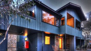 Een modern meerlaags huis met grote ramen en een balkon.