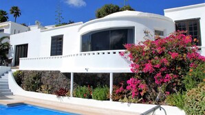 A white building with a curved facade, a large window, and a pool. - Private villa with stunning views and heated pool (Nazaret)