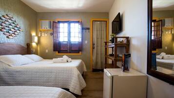Een hotelkamer met twee bedden, een televisie, een koelkast en een houten plank.