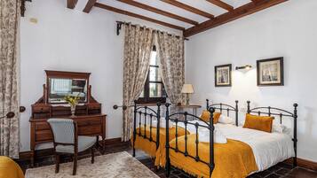 A bedroom with a wooden bed, a desk with a mirror, and a chair.