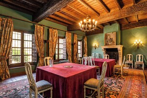 A room with a large chandelier, a fireplace, and a table set for dining.