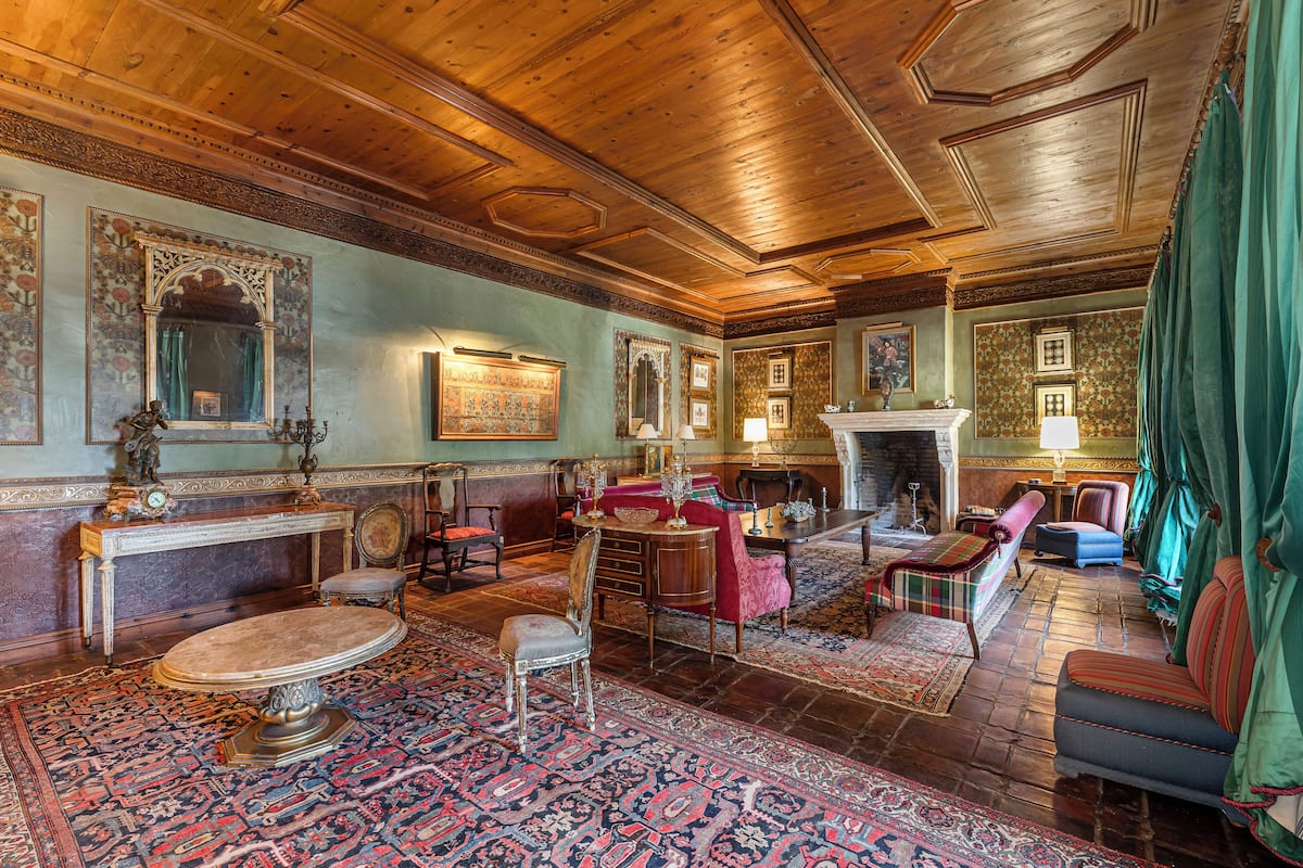 A traditional room with a fireplace, ornate furniture, and a patterned carpet.