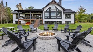 A modern house with a fire pit and outdoor seating.