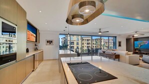 Una cucina moderna con isola centrale, elettrodomestici integrati e un'ampia finestra che si affaccia sulla città.
