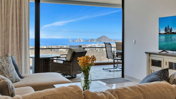 A balcony with a sofa, a table, and a TV.