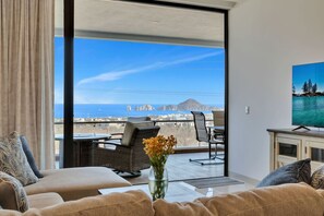 Een balkon met een bank, een tafel en een televisie.