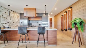 A modern kitchen with a central island, bar stools, and a decorative plant. - Ocean View, Overlooking Quivira, Infinity Pool (Cabo San Lucas)