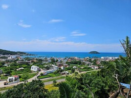 Un pueblo costero con una mezcla de edificios residenciales y comerciales, un cielo azul despejado y vistas al mar.